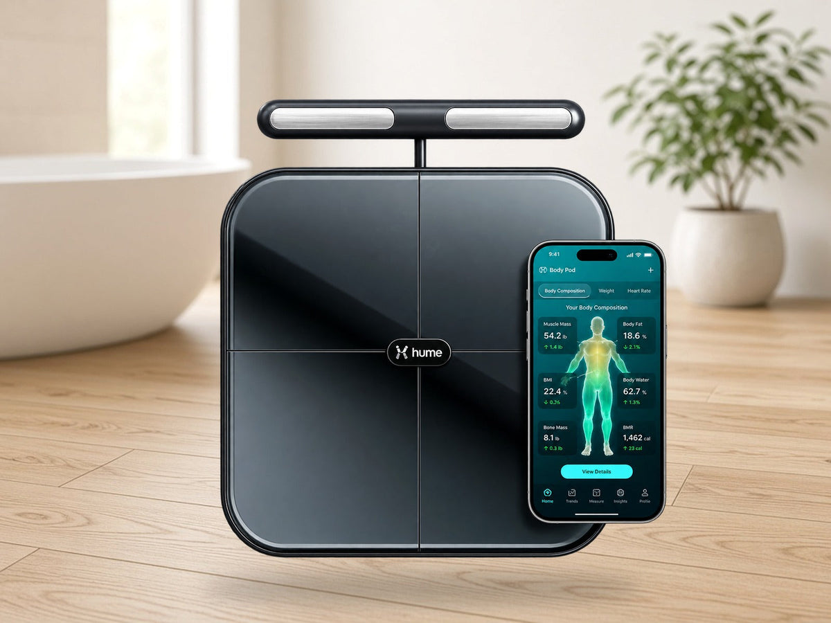 Hume Body Pod smart scale with handheld bar and Hume app in a softly lit modern bathroom