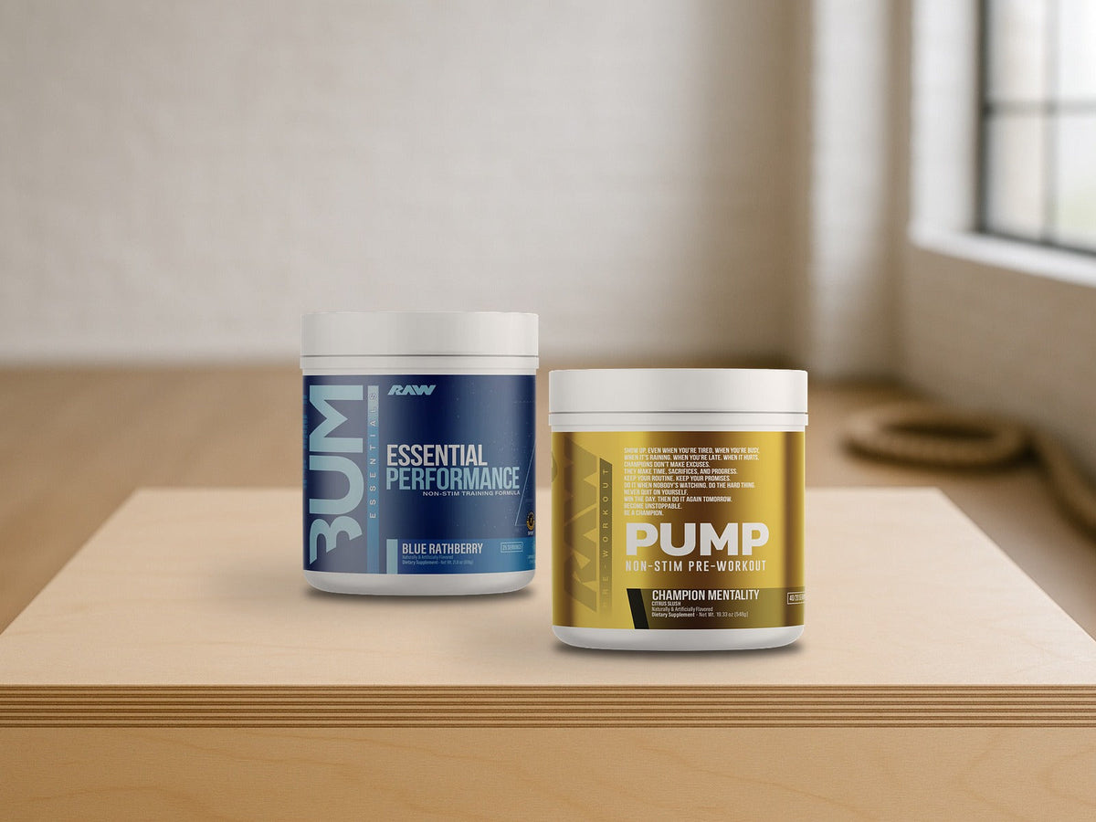 RAW Pump Non-Stim and RAW Essential Performance pre-workout tubs on a birch plyo box in a bright fitness studio, product clearly in focus