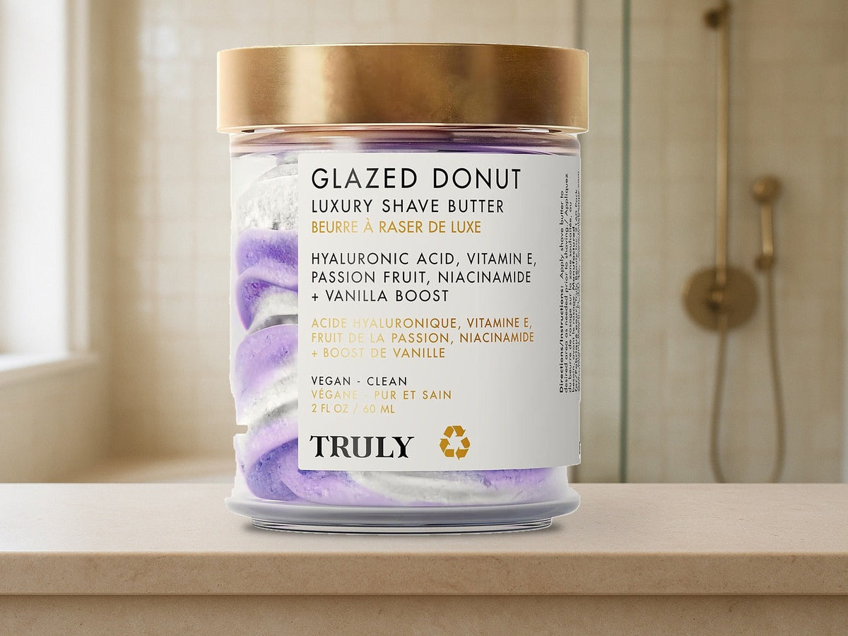 Truly Beauty Glazed Donut Shave Butter jar on a pale limestone bathroom ledge in soft morning window light, product clearly in focus